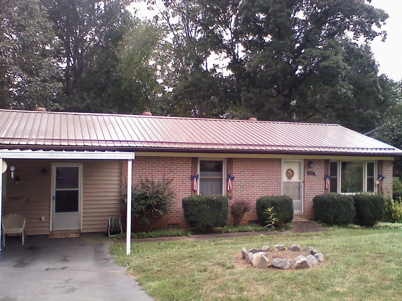 Bronze metal roof and carport on a brick ranch home — Roof Repair work by our crew in Fayette